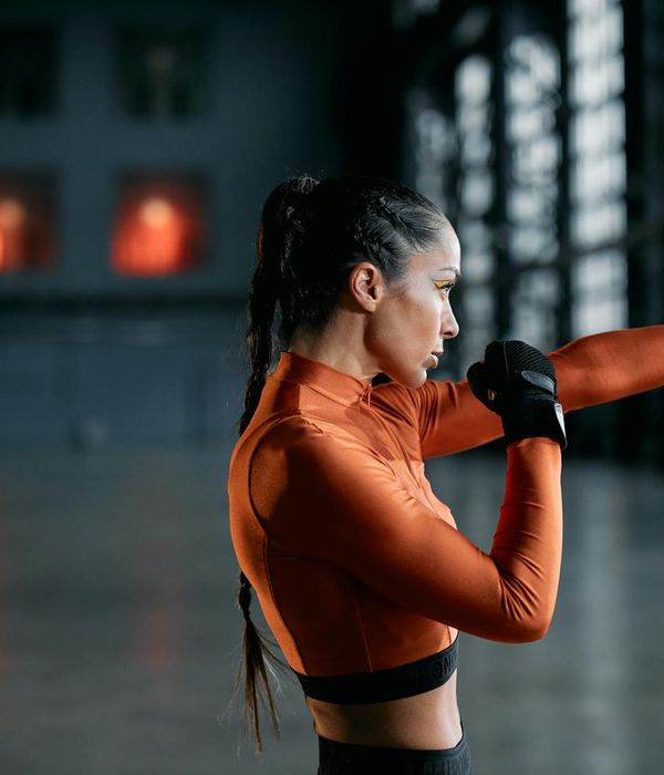 Woman performing a dynamic cardio exercise in a modern studio.